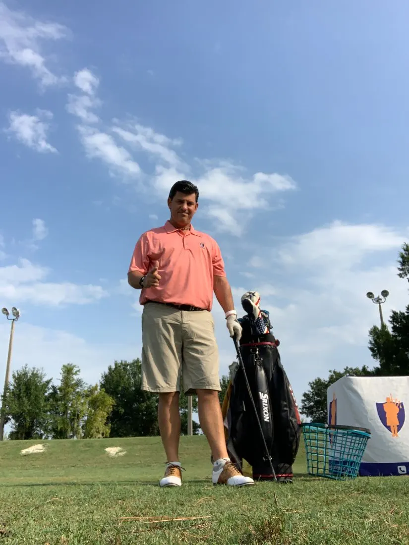 Tony Taylor, owner of In Phaze Electric, giving a thumbs-up on a golf driving range
